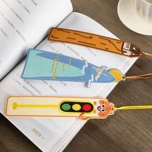 Set of creative handmade embroidered bookmarks with unique designs shown on an open book