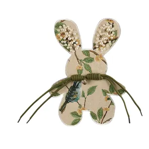 Vintage geborduurde konijnenpatch met bloemen, pareloren en groene koorddetails