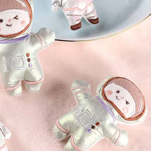 Cute plush astronaut patches with iridescent metallic fabric and embroidery.