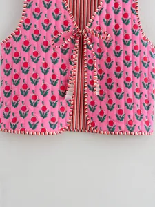 Close-up of pink floral quilted reversible vest with tie front and striped lining