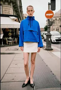 Stile urbano di una donna che indossa una giacca a vento blu impermeabile con cappuccio