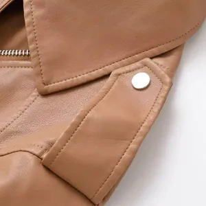 Gros plan d'un blouson de motard en similicuir marron avec bouton-pression argenté.