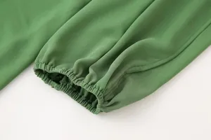 Gros plan détaillé montrant le poignet élastique d'une robe d'été verte à manches lanternes