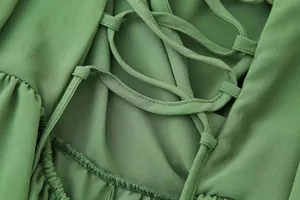 Gros plan détaillé sur le laçage élégant au dos d'une robe de printemps vert tendre