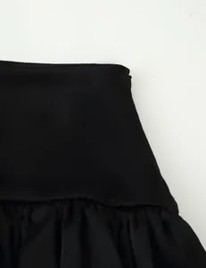 Detailed view of black tiered ruffle maxi skirt featuring pleated waist and fabric