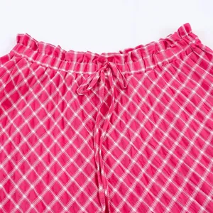 Close-up view of the elastic waistband and adjustable drawstring on a pink checkered midi skirt