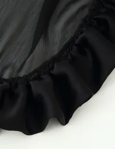 Macro detail shot showing black layered ruffle hem texture on elegant flowing skirt