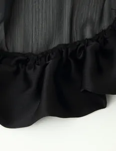 Close-up detail of the elegant black multi-layered ruffle hem on this summer skirt