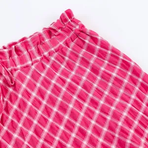 Detailed macro shot of a red and white plaid midi skirt featuring an elastic waistband.