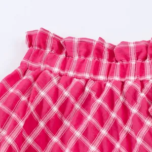 Detailed view of red and white plaid midi skirt featuring elastic ruffled waistband