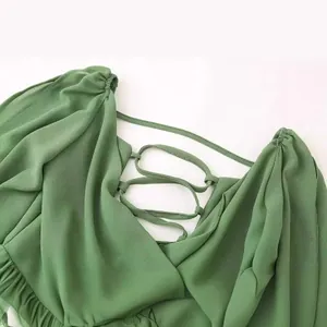 Gros plan d'une robe verte à manches lanternes et décolleté en V avec lanières