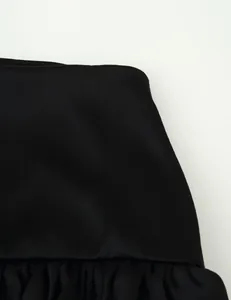 Close-up detail of black multi-layered ruffle skirt showing fine fabric texture