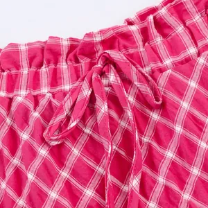 Macro detail of the elastic waistband and matching drawstring on a red plaid midi skirt