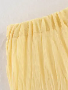 Vue détaillée de la texture du tissu plissé jaune d'une jupe mi-longue de printemps