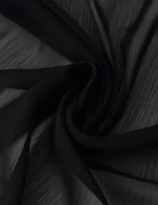 Detailed macro shot of high-quality black pleated chiffon fabric for elegant summer skirts.