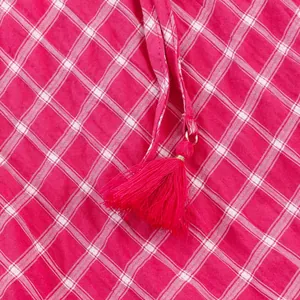 Detailed macro shot of a pink and white plaid midi skirt with a drawstring tassel