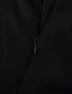 Close-up detail of black invisible zipper on tiered ruffled maxi skirt garment