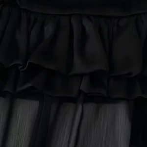Elegant black tiered ruffle long skirt featuring multi-layered chiffon fabric texture.