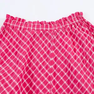 High-quality close-up detail of a pink checkered midi skirt with elastic ruffle waistband