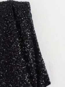 Nahaufnahme von schwarzem Paillettenstoff und Schulterpolster am ärmellosen Kleid