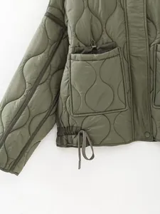 Close-up detail of olive green quilted winter jacket showing pocket design and hem drawstring