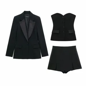 Conjunto de tres piezas negro con blazer de patchwork de satén, top bustier y shorts.
