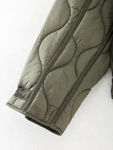 Detailed close-up view of olive green quilted jacket sleeve with onion pattern texture