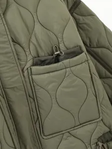 Macro detail of olive green quilted winter jacket showing unique drawstring pocket