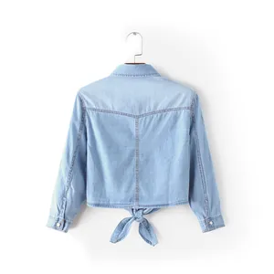 Petite veste chemise en jean bleu clair avec joli nœud à l'arrière sur fond blanc