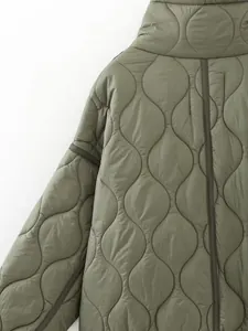 Close-up detail of olive green quilted puffer jacket with wavy stitching