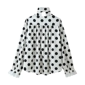 Back view of elegant polka dot blouse featuring unique choker neck and lace cuffs