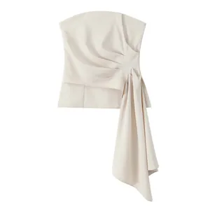 Close-up of elegant off-white strapless top with asymmetric pleated draping detail