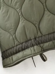 Close-up of olive green quilted jacket hem with mesh detail and adjustable drawstring