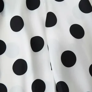 Detailed macro view of elegant black and white polka dot fabric texture for women