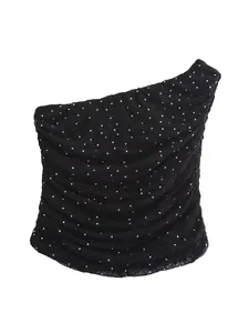Detail of black lace one-shoulder top with sparkling rhinestones and ruffled texture.