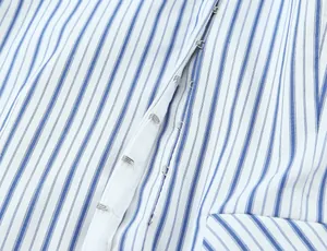 Dettaglio di un top a righe bianche e blu che mostra la chiusura con gancetti.