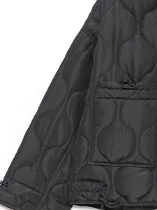 Macro detail of black wavy quilted women's jacket showing patch pocket and drawstring