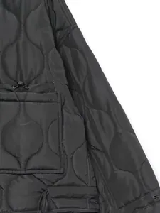 Close-up of wavy quilted texture and drawstring pocket detail on black winter jacket