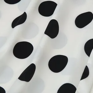 Macro detail of elegant white fabric with classic black polka dots and soft texture