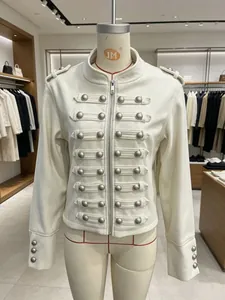 Close-up of military-inspired ivory wool jacket with decorative button trim detail