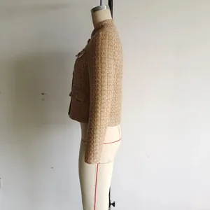 Dettaglio laterale di una giacca corta in tweed beige in stile francese da donna