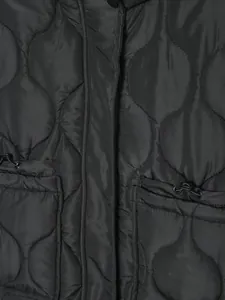 Close-up detail of black quilted winter jacket featuring onion stitching and pocket toggles