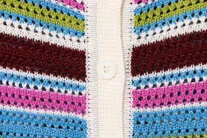Nahaufnahme eines bunt gestreiften Häkel-Oberteils mit Textur und Knopfdeteil