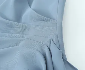 Detailed macro view showing the elegant pleated fabric texture of a light blue women's suit