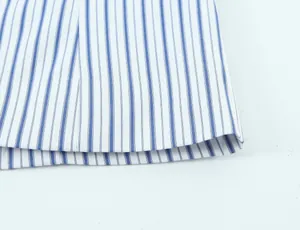 Dettaglio macro del tessuto estivo a righe bianche e blu con cuciture di qualità