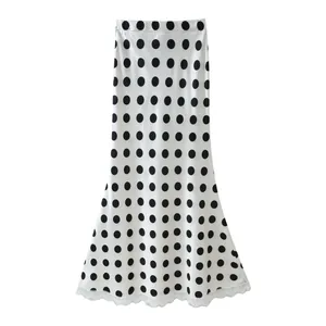 White high-waisted midi skirt with black polka dots and delicate lace hem detail
