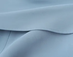 Macro view showing the close-up detail of high-quality stitching on light blue fabric