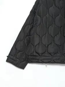 Close-up detail of black onion-pattern quilted winter jacket sleeve and hem line