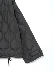 Detail view of black quilted winter jacket featuring onion quilting and drawstring hem