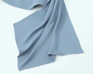 Close-up of elegant dusty blue pleated fabric showing smooth texture and stitching
